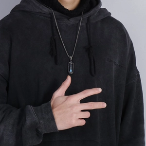 Close-up of a silver stainless steel chain with a creative blue sand hourglass pendant
