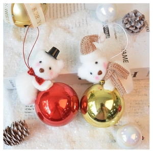 Detail of plush polar bear Christmas ornaments with red and gold balls in winter scene
