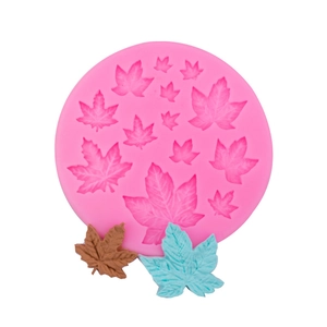 Pink silicone maple leaf mold with finished clay leaf shapes on a white background