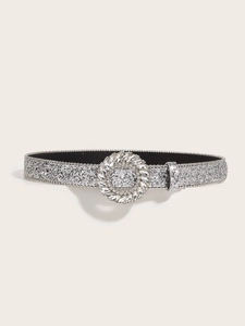 Detail of silver sequin belt with a large circular rhinestone buckle on beige background