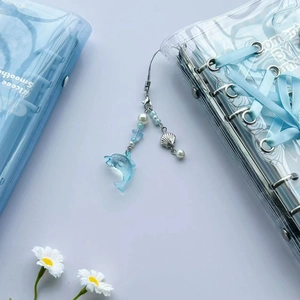 Blue dolphin beaded phone strap with pearls and silver shell charm on a light blue background