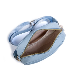 Light blue PU leather crossbody bag with wide strap and gold hardware on white background
