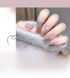 Detail of pink press-on nails featuring hand-painted clouds, stars and silver glitter