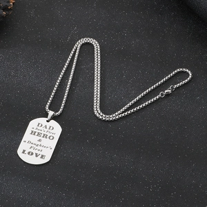Silver stainless steel dog tag necklace with Dad Hero engraving on dark textured background