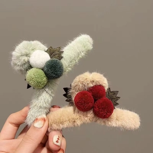 Plush cherry hair claws in green and beige with decorative pom-poms and fabric leaves