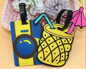 Close-up of colorful PVC pineapple and camera luggage tags with adjustable black straps