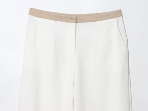 Detail of high-waisted white trousers with khaki contrast waistband and side pockets
