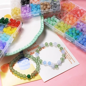 Flat lay of colorful 8mm glass beads in storage boxes for DIY jewelry making sets