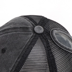 Detailed close-up of dark grey washed cotton baseball cap with mesh and goggle lens