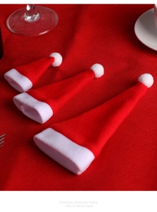 Three mini red and white felt Christmas hats used as festive cutlery and bottle holders