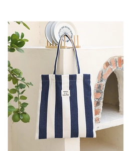 Detail of blue and white striped canvas tote bag with SEASON 12 lettering and twin handles