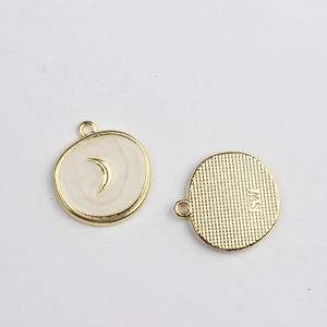 Macro detail of alloy star and moon pendant with white enamel and SW engraving