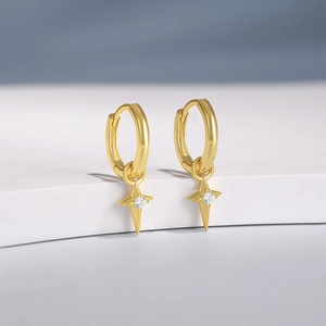 Detail of gold starburst hoop earrings with sparkling cubic zirconia on a white stand