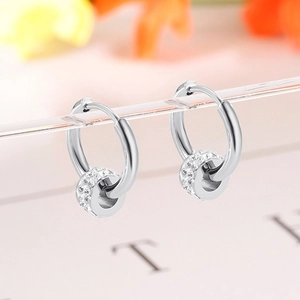 Elegant silver cylinder hoop earrings with micro-pave crystals on a floral background