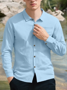 Detail of light blue linen shirt featuring seersucker texture and amber buttons