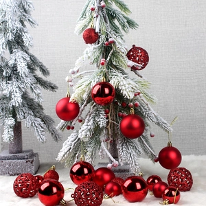 Red Christmas ornaments set with matte and glitter finishes on a snowy mini tree
