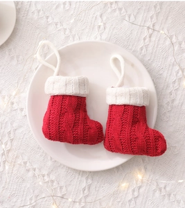 Close-up of mini red knitted Christmas stockings for cutlery on a white ceramic plate