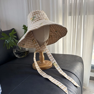 Wide brim yellow checkered sun hat with floral embroidery and adjustable neck ties