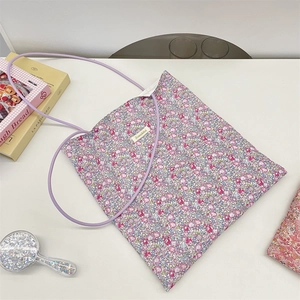 Detail of floral canvas tote bag with pink-purple patterns and thin purple shoulder straps