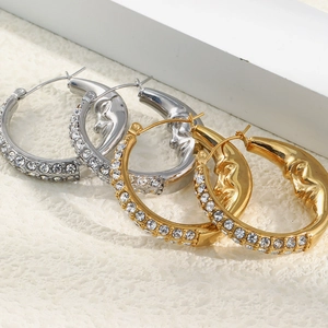 Detail of moon face hoop earrings with 18K gold plating and sparkling zircon stones