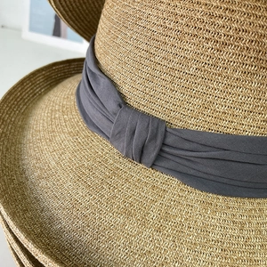Women's elegant straw sun hat with wide brim and dark grey chiffon ribbon detail