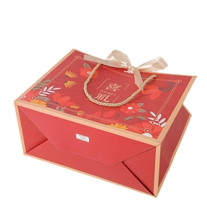 Detail of red floral Chinese gift box with gold wishes text and champagne silk bow