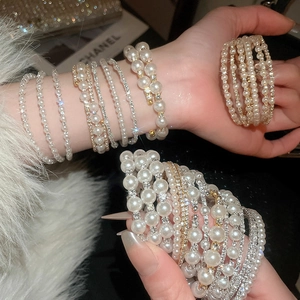 Close-up of multi-layer pearl and rhinestone bracelet set with elegant gold finish