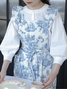 Detail of floral porcelain print apron with ruffled straps and waist ties in cotton