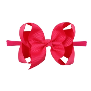 Pink ribbon bow headband for babies with elastic nylon strap on white background