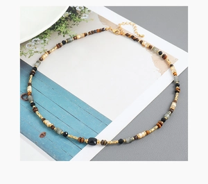 Detail of beaded ethnic necklace with natural stone shells and lobster clasp on magazine