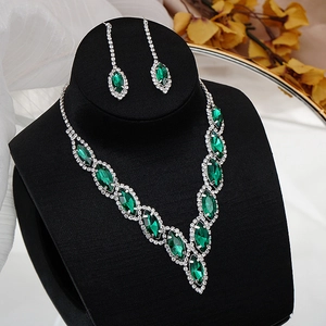 Macro shot of emerald green crystal bridal necklace and earrings set on velvet