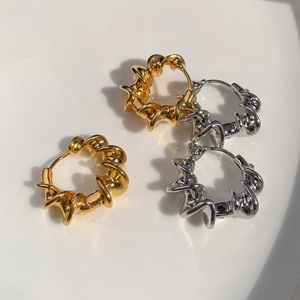 Minimalist geometric twisted gold and silver hoop earrings with metallic polished finish
