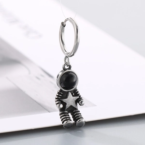 Detail of a stainless steel astronaut drop earring with a black enamel helmet on white