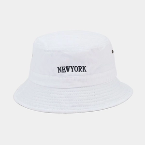 Close-up of NEWYORK embroidery and metal eyelet on a white washed cotton bucket hat
