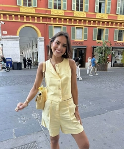 Detail view of yellow linen-textured sleeveless vest and matching shorts set for women