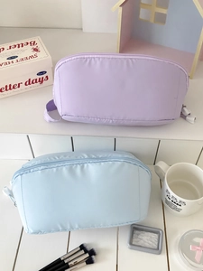 Large macaron colored travel makeup bags in purple and blue with top handle and zipper