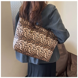 Détail du sac cabas imprimé léopard avec anses en cuir marron et rivets métalliques