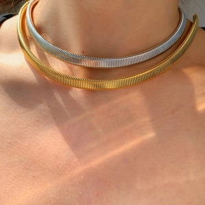Close-up of minimalist flat snake chain necklaces in gold and silver on model neck