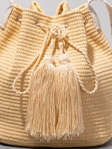 Solid color woven straw bucket bag with tassels and drawstring for beach vacations
