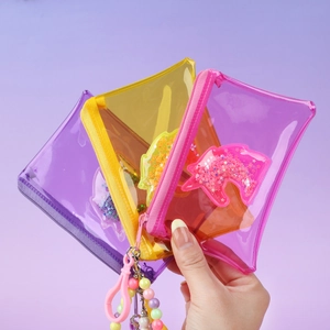 Hand holding three glitter unicorn PVC square coin purses in purple, yellow, and pink colors