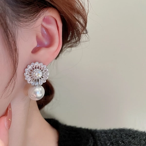Elegant zircon flower earrings with white pearl pendant worn by a female model