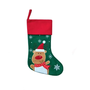Détail d'une chaussette de Noël en feutre vert avec renne brodé et motifs de flocons