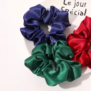 Three-piece silk satin scrunchies set in vibrant royal blue, emerald green, and red