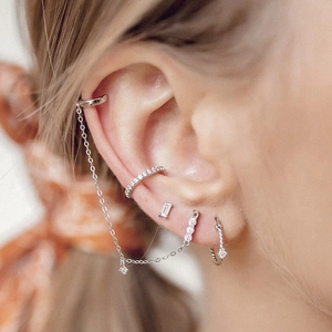 Close-up of S925 silver stud earrings set with micro-paved cubic zirconia and ear cuffs
