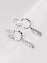 Close-up of silver geometric clip-on earrings with soft silicone pads and rectangular bars