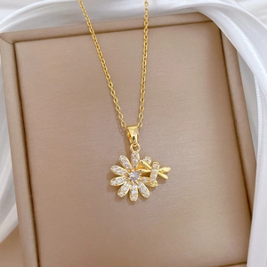 Detailed close-up of golden daisy and dragonfly pendant set with sparkling crystals