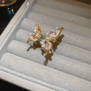Close-up of butterfly ring with colorful crystals and pearls on a velvet jewelry box