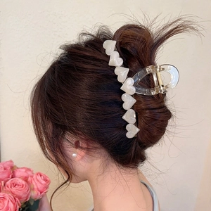 Transparent jelly heart hair claw clip for women shown on back of head for hairstyle