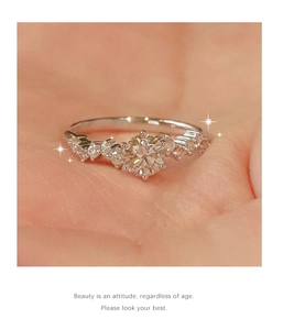Macro shot of a shimmering silver multi-stone halo engagement ring held on a palm