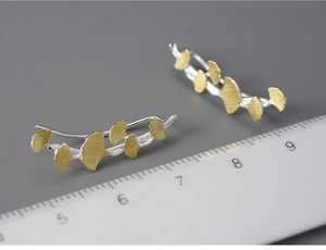 Macro shot of S925 sterling silver ginkgo leaf earrings with ruler for size reference